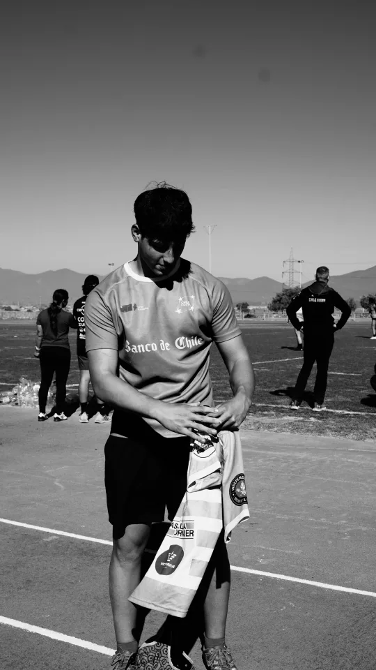 Joaquín dobla una camiseta de juego de pie en la cancha, en blanco y negro