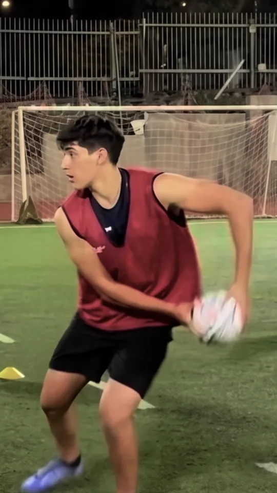 Joaquín sujeta el balón con una mano y gira el cuerpo para pasarlo, en un entrenamiento